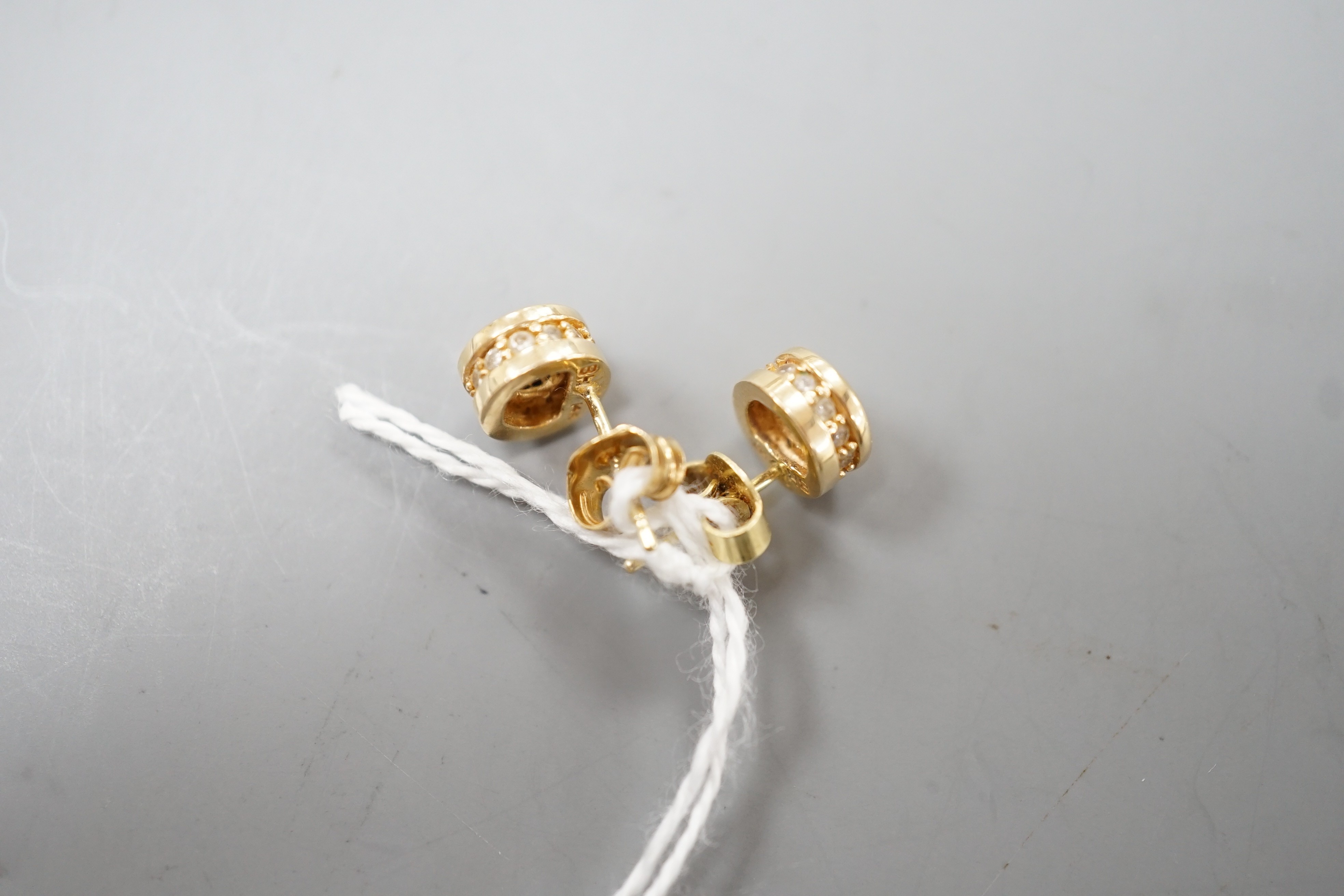 A modern pair of 14k yellow metal and single stone diamond set ear studs, with diamond chip setting, diameter 6mm, gross weight 2.8 grams.